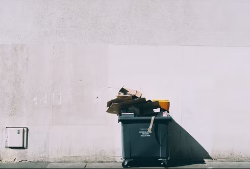 Garbage disposal box ahead of a white wall