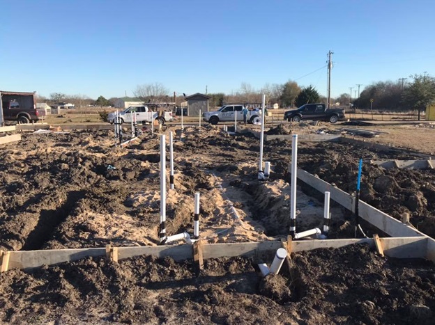 Underground plumbing system in a house foundation