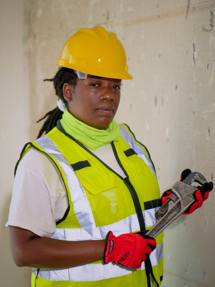 A professional plumber holding a wrench.