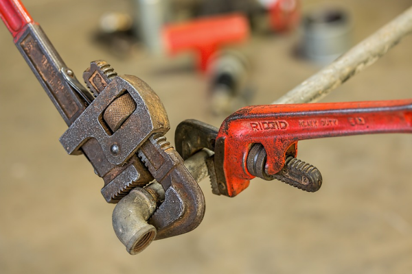an image of wrenches repairing a pipe